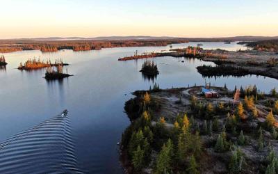 Vue aérienne d’une foreuse au diamant et d’équipes d’échantillonnage de sol en cours de mobilisation sur le lac Frotet.