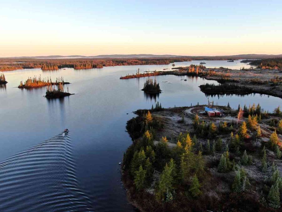 Vue aérienne d’une foreuse au diamant et d’équipes d’échantillonnage de sol en cours de mobilisation sur le lac Frotet.