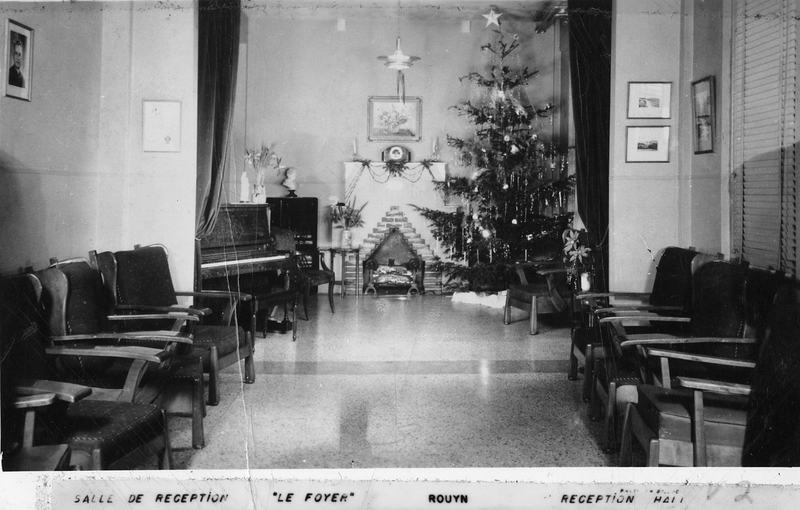 La salle de réception du Foyer Saint-Raphaël, à Rouyn, en 1937, apparaît comme un espace sobre et fonctionnel, aménagé pour accueillir les femmes hébergées par l’institution. Ce lieu sert à la fois d’espace de rassemblement, de repos et de sociabilité.